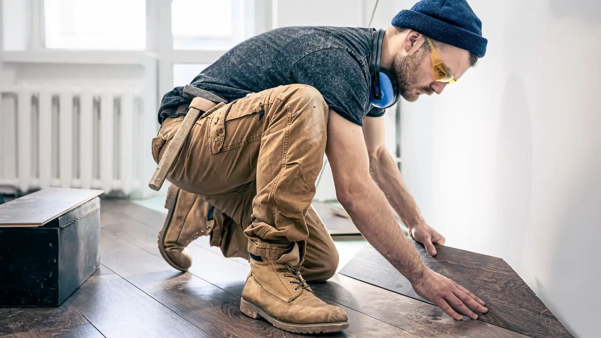 a male worker puts laminate flooring on the floor